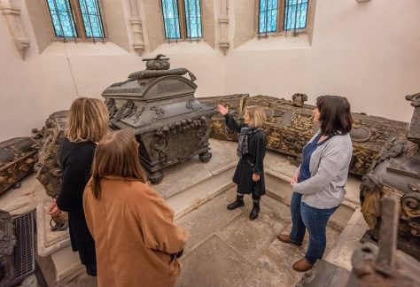 Eine Gruppe steht vor verzierten Särgen in der Fürstengruft des Merseburger Doms